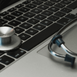 Mesa de um consultório médico moderno com notebook em ambiente escuro, representando a aplicação de SEO para clínicas e estratégias de marketing na saúde.